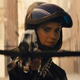 Wearing a motorcycle helmet with the visor up, Huntress (Mary Elizabeth Winstead) fires a crossbow at the camera in a scene from Birds of Prey.